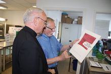 Heinz Steege erläutert Bischof Algermissen die Kalligraphie von Karlos Aha.